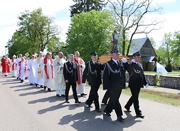 Widać strażaków i kapelanów idących na czele pielgrzymki