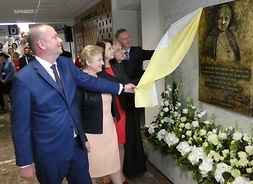 przedstawiciele samorzadu województwa odsłaniają szarfę z tablicy pamiatkowej z wizerunkiem Jana Pawła II