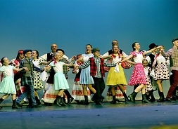 Tancerze w kostiumach występują na scenie
