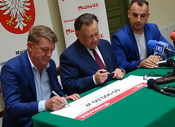 Marszałek Adam Struzik i dyrektor Tomasz Kominek podpisują czek z beneficjentem