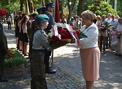 Elżbieta Lanc, członek zarządu województwa przekazuje harcerce wieniec do złożenia pod pomnikiem AK