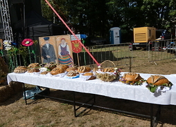 Obok sceny na stolikach leżą chleby dożynkowe