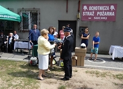 Wicemarszałek Jania Ewa Orzełowska i członek zarządu Elżbieta Lanc przekazują ubrania strażakom