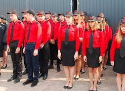 młodzieżowa drużyna pożarnicza w czerwono-czarnych strojach