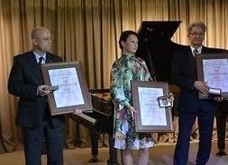medale pamiątkowe trzymają w rękach Monika Patrowicz, Gabriel Wieczorek i Waldemar Kuciapski