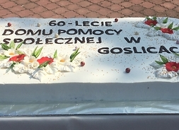 duży tort z napisem 60 lat Domu Pomocy Społecznej w Goślicach