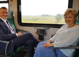 Elżbieta Lanc i Rafał Rajkowski siedzą na fotelach w nowym pociągu