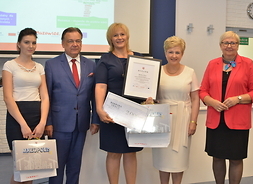 Marszałek oraz członek zarządu województwa Elżbieta Lanc stoją w otoczeniu kilku nagrodzonych nauczycieli
