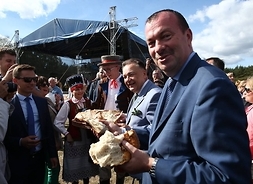 marszałek Adam Struzik i wicemarszałek Wiesław Raboszuk dzielą się chlebem z uczestnikami dozynek
