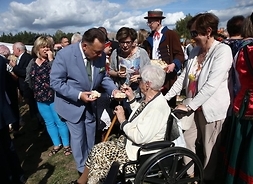 marszałek Adam Struzik dzieli się chlebem ze starszą mieszkanką Mazowsza na wózku