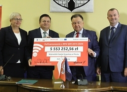 Czworo samorządowców trzymających symboliczny czek na remont szpitala w wysokości ponad 5,5 mln zł