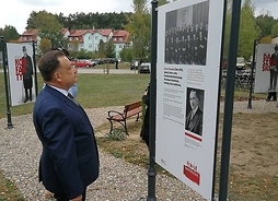 marszałek Adam Struzik stoi przed pamiatkową tablicą w Parku Niepodległości