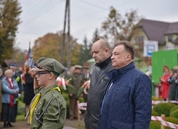 Marszałek i dyrektor Radosław Rybicki stoją przed pomnikiem. Przed nimi stoi mały harcerz