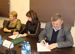 umowy podpisują, siedząc przy stole, członkinie zarządu województwa Elżbieta Lanc i Janina Ewa Orzełowska burmistrz Sokołowa Podlaskiego Bogusław Karakula