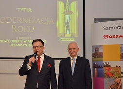 marszałek Adam Sruzik z mikrofonem w ręku, obok prezes Roman Pikuła, komisarz konkursu