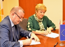 wicemarszałek Wiesław Raboszuk, członek zarządu województwa mazowieckiego Elżbieta Lanc w pozycji siedzącej podpisują umowy