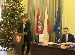 przy mównicy przemawia radny Krzysztof Strzałkowski, z lewej strony przy stole siedzi przewodniczący sejmiku Ludwik Rakowski