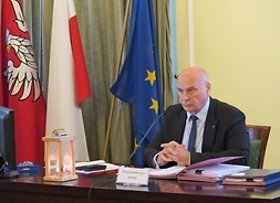 Tomasz Kucharski Wiceprzewodniczący Sejmiku Województwa Mazowieckiego siedzi za stołem, prowadzi sesję sejmiku