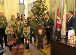 z lewej stoją przewodniczący sejmiku Ludwik Rakowski, marszałek Adam Struzik, po prawej stoją harcerze ze światłem pokoju z groty Narodzenia Pańskiego w Betlejem