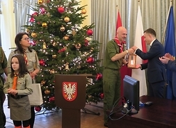 Harcerze z Mazowieckiej Chorągwi ZHP przekazują na ręce przewodniczącego Ludwika Rakowskiego światło Pokoju