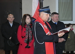 Na zdjęciu widać modlącego się księdza. Na drugim planie widać Janinę Ewę Orzełowską członek zarządu i Grzegorza Górala wójta gminy Kotuń.
