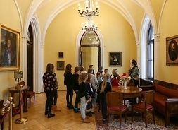 zwiedzanie sal muzealnych, przed obrazem stoi grupa dzieci z historykiem sztuki