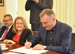 Umowę przy stole podpisuje burmistrz Ożarowa Mazowieckiego Paweł Kanclerz