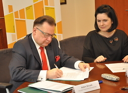 Umowę podpisuje marszałek Adam Struzik, obok przy stole siedzi zastępdca dyrektora ds. EFRR w MJWPU Monika Tchórznicka