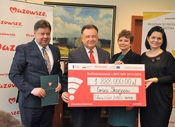 Beneficjenci projektu gminy Skaryszew pozują do zdjęcia z symbolicznym czekiem