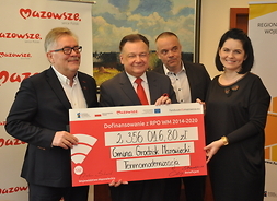 Beneficjenci projektu gminy Grodzisk Mazowiecki pozują do zdjęcia z symbolicznym czekiem