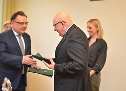 Sekretarz Województwa – Dyrektor Urzędu Waldemar Kuliński trzyma w dłoni list gratulacyjny