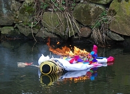 Płonąca Marzanna, czyli barwnie ubrana i przystrojona, słomiana kukła, unosi się na wodzie.