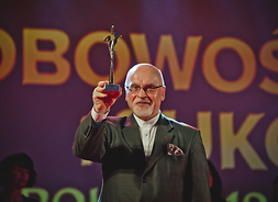 Roman Kochanowicz prezentuje statuetkę