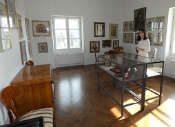 W pałacu - widzimy wnętrze i eksponaty w sali z dziełami malarskimi Wandy Ostrowskiej – matki Beaty Ostrowskiej.