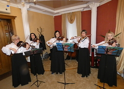 Grupa pięciu kobiet gra na skrzypcach