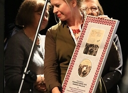 Aneta I. Oborny, redaktorka nagrodzonej publikacji, prezentuje dyplom