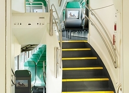 wnętrze pociągu Kolei Mazowieckich, widoczne są dwa piętra połączone schodami