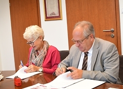 Dr Jarosław Rosłon podpisuje umowę