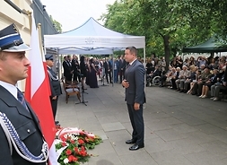 Przed tablicą upamiętniającą żołnierzy Armii Krajowej Grupy „Krybar”, poległych podczas Powstania Warszawskiego stoi wiceprzewodniczący sejmiku Mirosław Adam Orliński