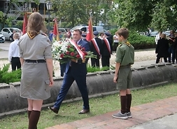 Wiceprzewodniczący sejmiku Marcin Podsędek składa wieniec przy pomniku Romualda Traugutta, przy którym pełnią wartę harcerze