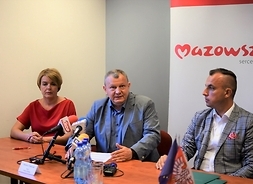 Za stołem siedzą trzy soby, drugi od lewej zabierający głos wójt gminy Zawidz Dariusz Franczak.