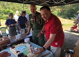 marszałek Adam Struzik kroi jubileuszowy tort w asyście kadry harcerskiej