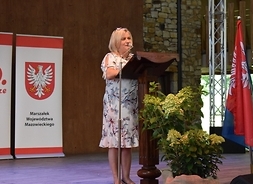 przy mównicy stoi dyrektor Muzeum Wsi Radomskiej w Radomiu Ilona Jaroszek