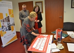 Elżbieta Lanc podpisuje symboliczny czek