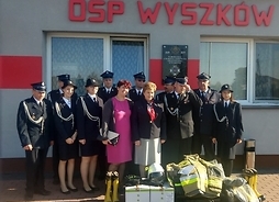 przed budynkiem strażnicy stoją strażacy OSP Wyszków i zzłonek zarządu województwa Elżbieta Lanc