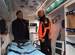 wewnątrz ambulansu ratownictwa medycznego stoi ratownik medyczny i marszałek Adam Struzik