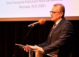Stoi na scenie i mówi do mikrofonu Tomasz Sieradz, dyrektor Wojewódzkiego Urzędu Pracy w Warszawie .