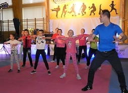 Dzieci ze studia Love Dance wraz z trenerem - na scenie podczas pokazu tańca nowoczesnego.
