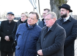 Marszałek Adam Struzik i radny wojewódzki Leszek Przybytniak w gronie kilku samorządowców lokalnych, stoja na poboczu podczas otwarcia drogi.