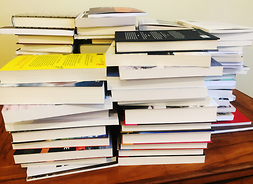 Na stole leżą ułożone w kilku stosach książki nominowane do Nagrody Literackiej im. Witolda Gombrowicza 2020.